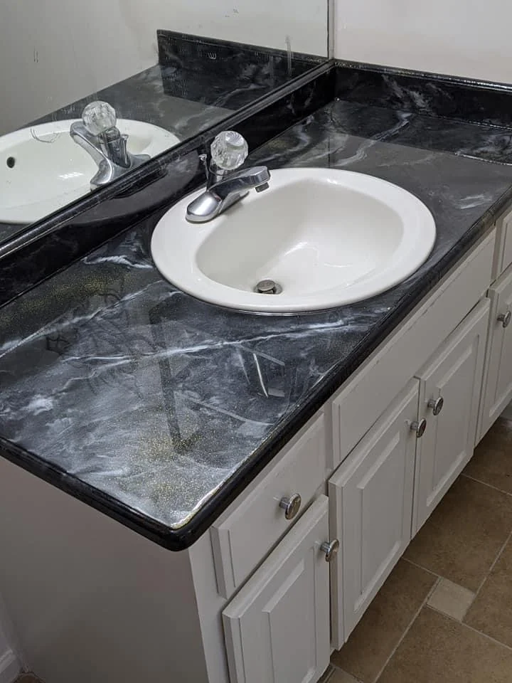 Bathroom vanity with a dark patterned countertop