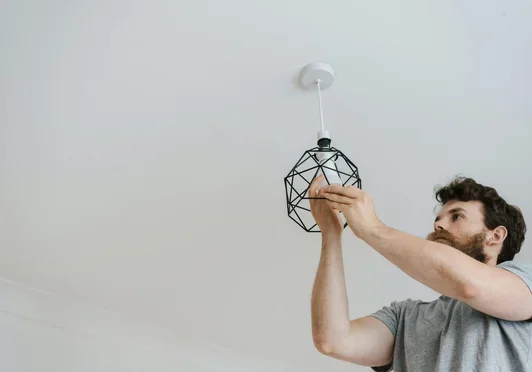 Worker installing a light fixture
